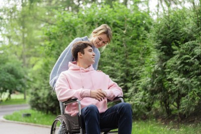 Žena tlačí muža na invalidnom vozíku